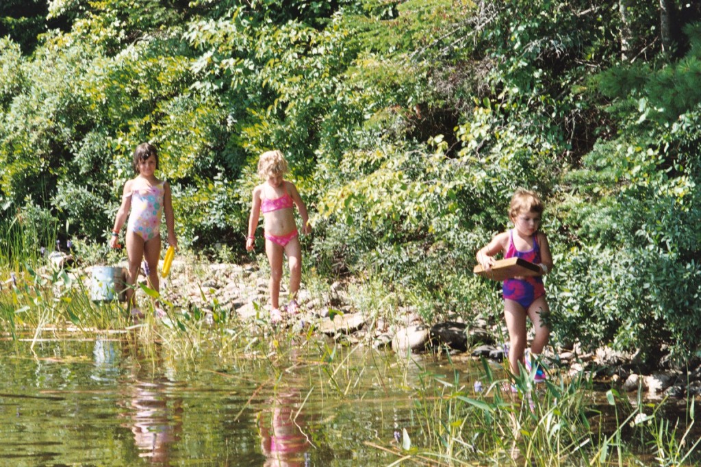 Three little girls trying to catch some frogs on Bog Lake in Down East Maine