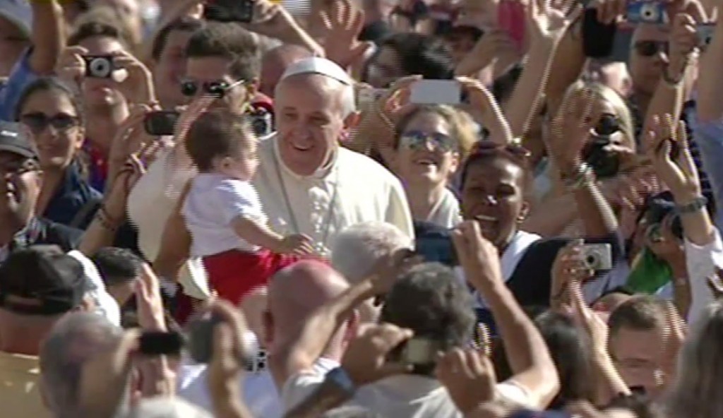 Pope Francis kisses a baby at his weekly audience in St. Peter's Square. September 19, 2013. Freeze Frame of video shot by Gianfranco Stara.