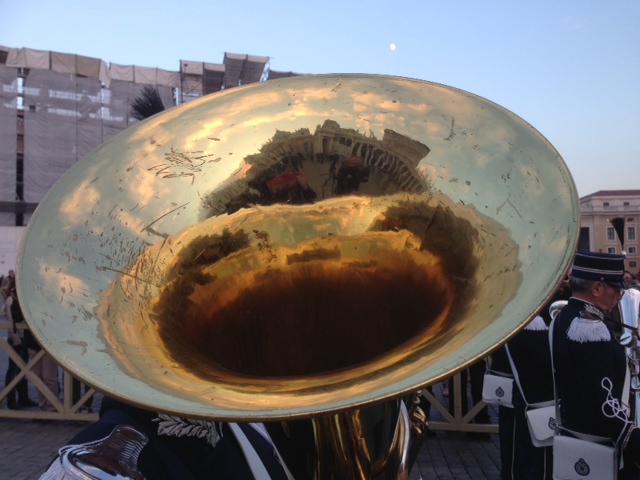 The reflection of St. Peter's Basilica and Bernini's Colonnade reflected in the horn used by a member of the marching band in the Christmas Tree Lighting Ceremony in St. Peter's Square. December 13, 2013. Photo by Trisha Thomas
