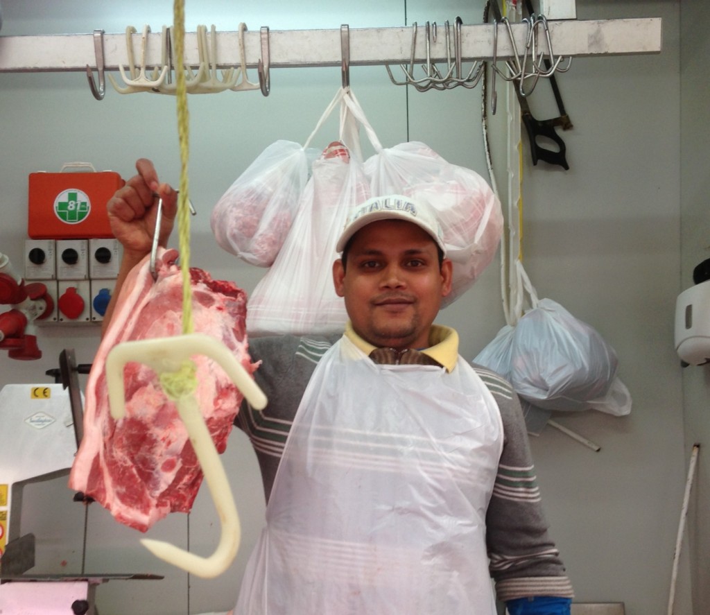 Filippo from Bangladesh working at a butcher stand at Piazza Vittorio market in Rome. February 3, 2014. Photo by Trisha Thomas