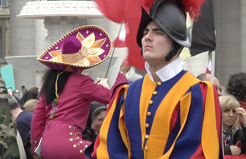 Swiss Guard in St.Peter's Square with Mexican pilgrim in background at canonization mass for two popes. April 27, 2014. Freeze frame of video shot by AP cameraman Pietro De Cristofaro