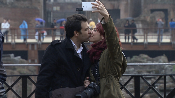 Couple doing a "kissing selfie" at Colosseum in Rome. Freeze frame of video shot by AP Television cameraman Gigi Navarra. November 26, 2014