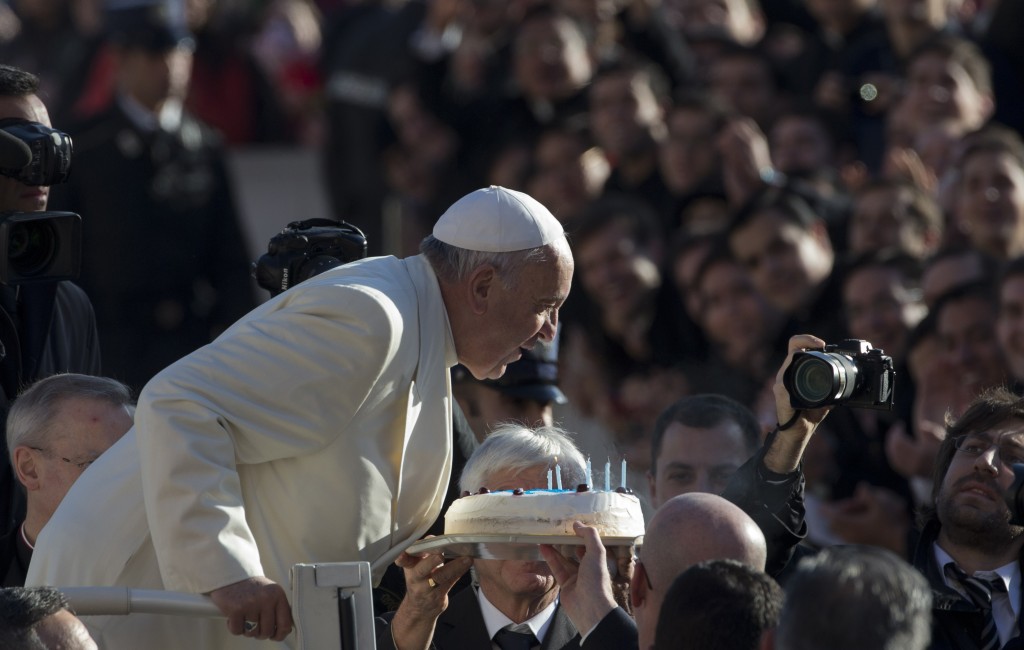 Pope Francis blows out candles on a birthday cake for his 78th birthday during his weekly audience in St. Peter's Square. Photo by AP photographer Alessandra Tarantino for Mozzarella Mamma. December 17, 2014