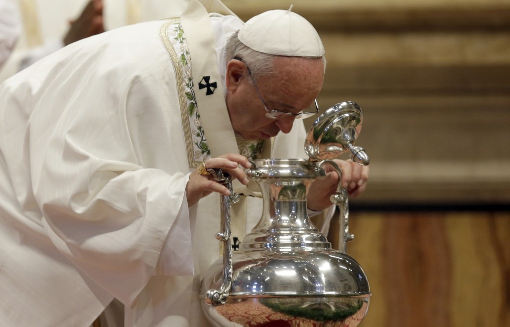 Pope Francis blowing inside a vat containing oil to be used in the sacraments in parishes in Rome throughout the year during Chrism Mass in St. Peter's Basilica on Holy Thursday.  Photo by AP photographer Gregorio Borgia for Mozzarella Mamma 