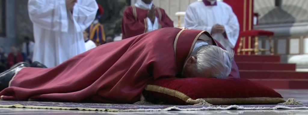 Pope Francis lies on the floor in prayer during the Celebration of the Passion of Christ in St. Peter's Basilica. April 3, 2014.  Freeze frame of Vatican TV video.