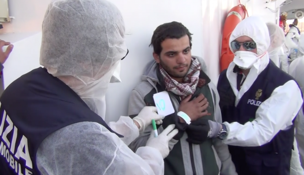 Italian police arresting an alleged Tunisian trafficker aboard the Coast Guard ship Fiorillo. April 16, 2015. Freeze frame of video shot for AP Television by Gino Maceli