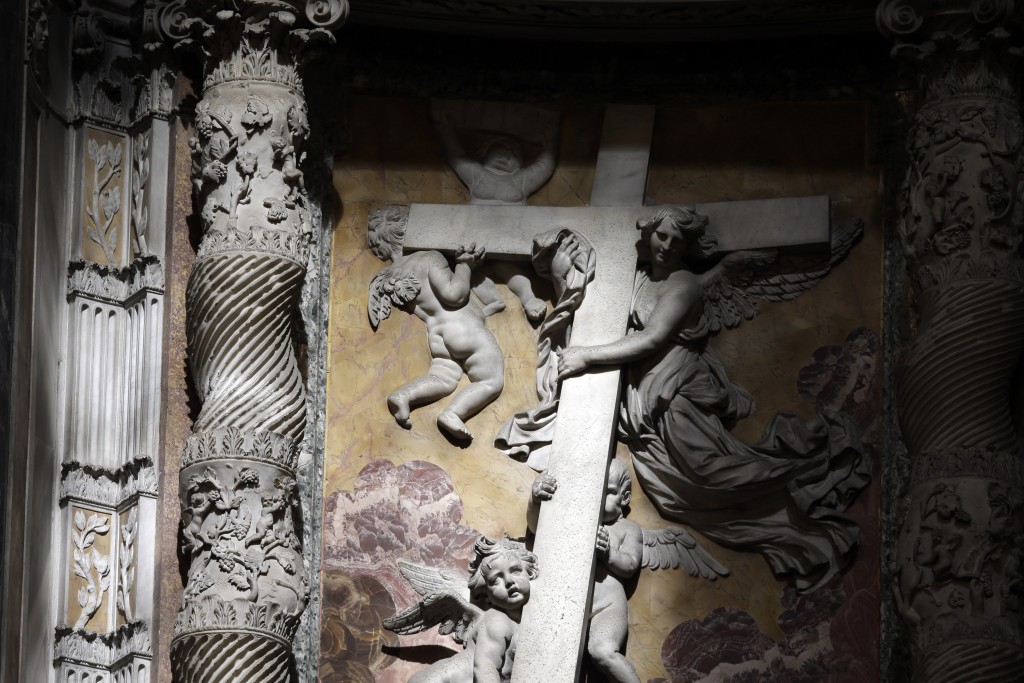 An angel and cherubs struggle under the weight of the cross on a relief on the wall in St. Peter's Basilica. Photo taken for Mozzarella Mamma by Gregorio Borgia during the Chrism Mass April 2, 2015