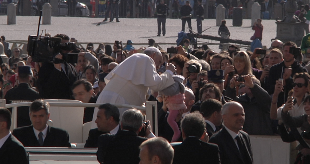 Pope Francis kisses baby during weekly audience in St. Peter's Square, April 1, 2015. Freeze frame of video shot by AP Television cameraman Gianfranco Stara.
