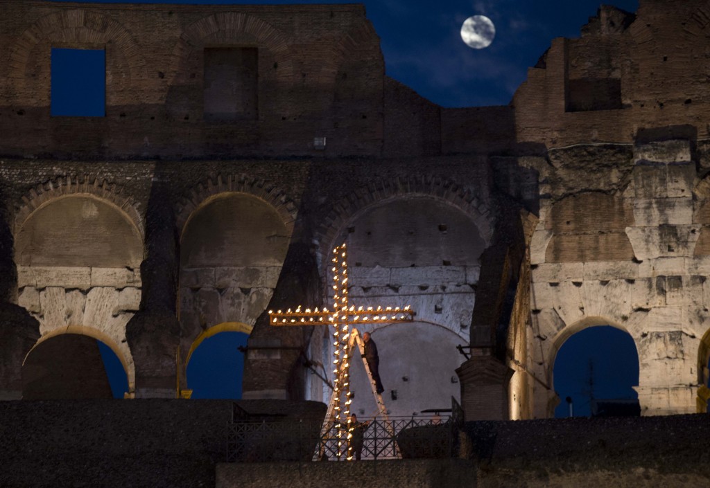 Workers light candles on cross inside the Colosseum as they prepare for the Via Crucis (Way of the Cross) with Pope Francis. April 3, 2015. Photo by AP photographer Alessandra Tarantino for Mozzarella Mamma