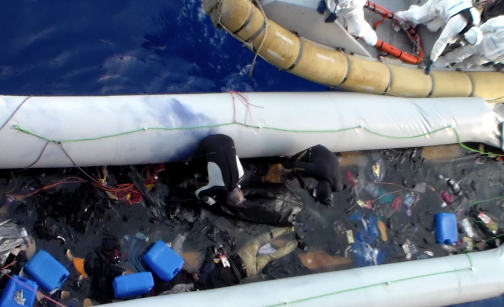 Sailors taking bodies of dead migrants from dinghy and putting them in body bags. May 2015. Freeze frame of video shot by Polish seaman. (Video copyright AP Archive. www.aparchive.com )