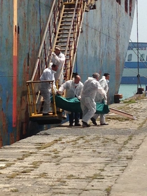The body of a migrant who died crossing the Mediterranean being carried off the merchant ship Zeran. May 5, 2015. Photo by Trisha Thomas