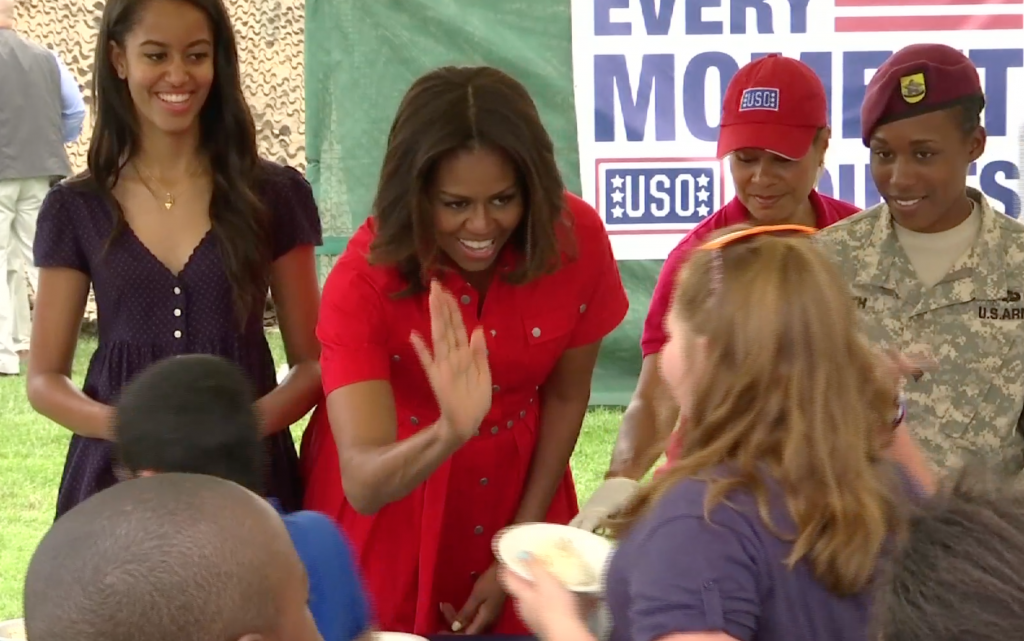 First Lady Michelle Obama serving ice cream to children at the US Army Garrison in Vicenza, Italy. June 19, 2015.  Freeze frame of video shot by AP Cameraman Gigi Navarra.