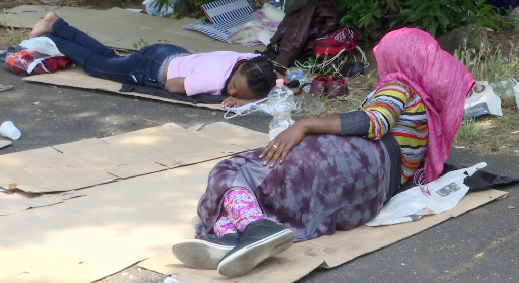 Migrant women lying on cardboard on ground at Tiburtina bus terminal in Rome. June 11, 2015. Freeze frame of video shot by AP Television Cameraman Luigi Navarra