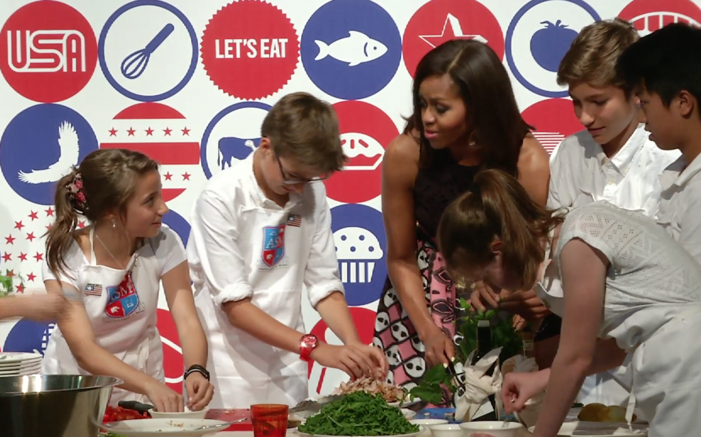 First Lady Michelle Obama cooking with American kids at the James Beard American Restaurant in Milan. June 17, 2015. Freeze frame of video shot by AP Television cameraman Gigi Navarra