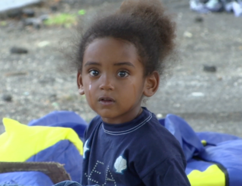 Little migrant girl sitting on ground at Tiburtina bus terminal in Rome. June 11, 2015.     Freeze frame of video shot by AP Television cameraman Luigi Navarra.