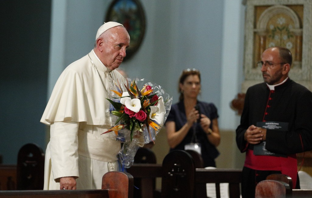 Pope Francis arrives with a bouquet of flowers at the Sanctuary of the Virgen de la Caridad in Cobre, Cuba. September 21, 2015. (That is me, Trisha Thomas watching in the background, holding my cell phone and ready to take photos.) Photo by Paul Haring of Catholic News Service for Mozzarella Mamma. September 21, 2015