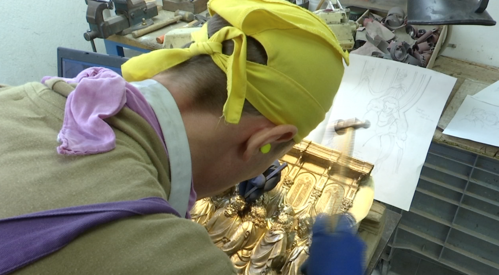Artist Andrea Romanelli chiseling the hair on the figures in "The Last Supper" Panel on the replica of Ghiberti's North Doors. Freeze frame of video shot by AP Cameraman Gigi Navarra. November 20, 2015