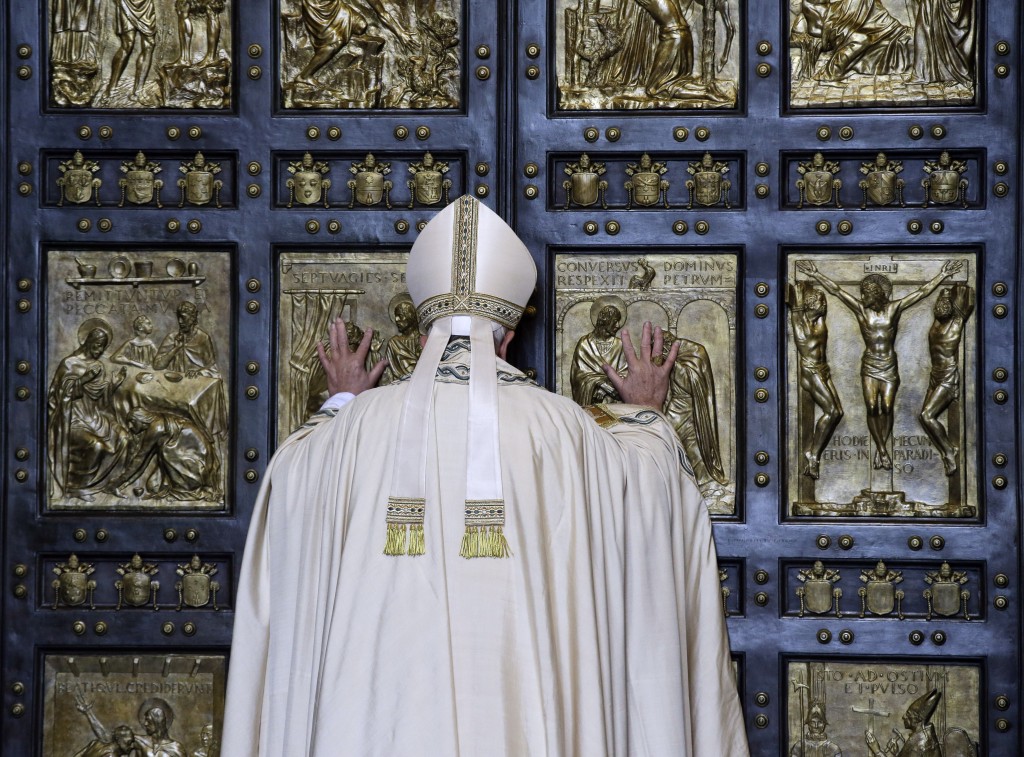 Pope Francis pushes open the Holy Door on St. Peter's Basilica. December 8, 2015. Photo by AP Photographer Gregorio Borgia
