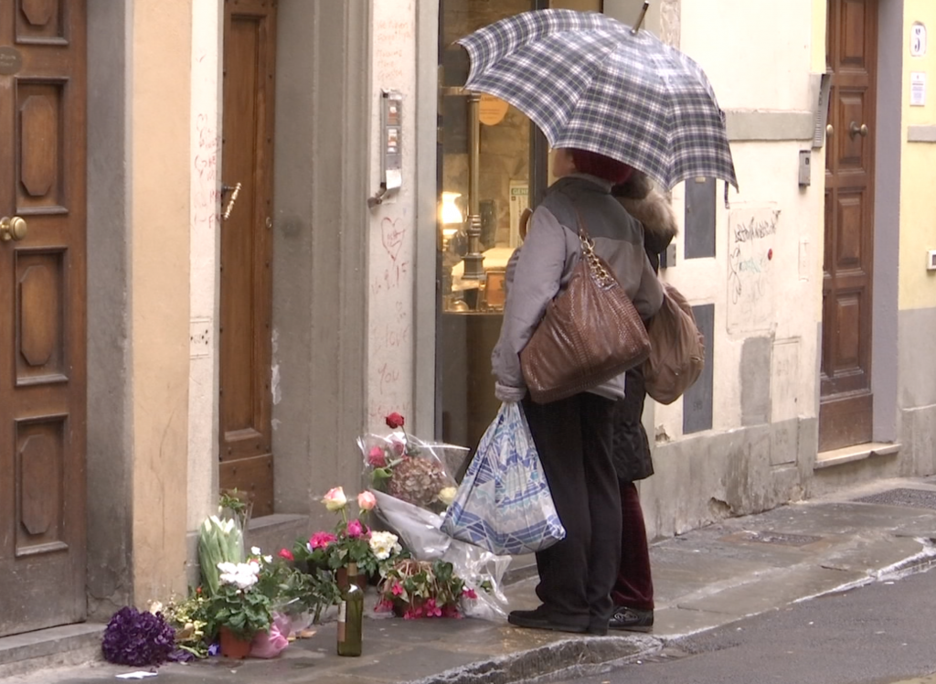 Passersby read messages left by friends of Ashley Olsen outside her apartment in Florence. Freeze frame of video shot by AP Cameraman Gigi Navarra for Associated Press Television. January 14, 2016