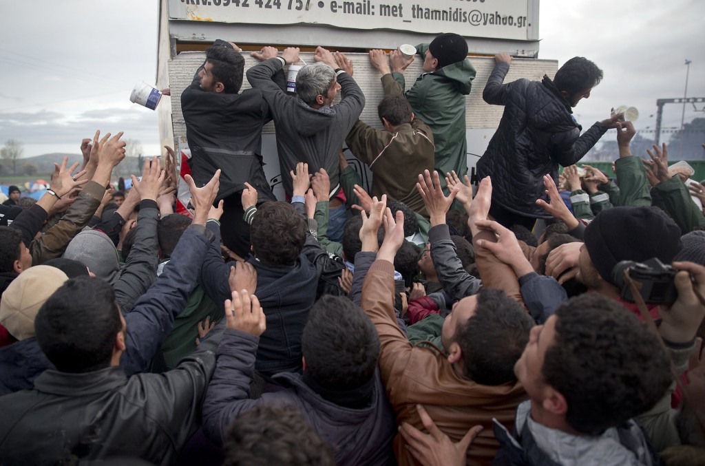 Migrants reaching for food handouts from trucks in the village of Idomeni, Greece on the border with Macedonia. March 2016