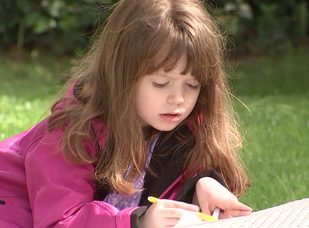 Five-year-old Lizzy Myers drawing in a garden in Rome. Freeze frame of video shot by AP Television Cameraman Paolo Lucariello. April 2, 2016