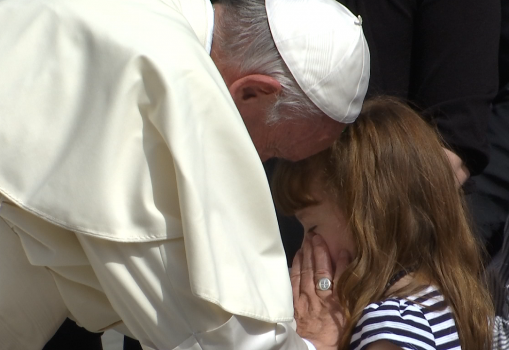 Pope Francis caresses the eyes of Ohio girl Lizzy Myers at the end of his weekly audience. April 6, 2016. Freeze frame of video shot by AP Television cameraman Gianfranco Stara