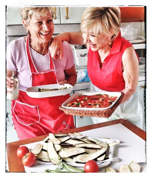 Katherine Wilson's mother-in-lawe working on a Parmiginana di Melanzane (Eggplant Parmesan) dish with her sister. Credit: Tara Crossley