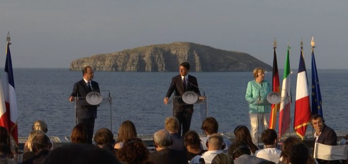 French President Francois Hollande, Italian Prime Minister Matteo Renzi, and German Chancellor Angela Merkel speak to the press aboard the aircraft carrier Garibaldi with the island of Ventotene in the background. Monday, August 22, 2016. Freeze frame of video shot by AP Television cameraman Gianfranco Stara.