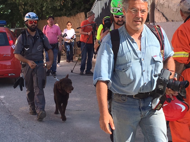 AP Photographer Gregorio Borgia stepped into my photo as I was trying to catch Klaus, the chocolate labrador rescue dog with his companion Carlo Apollo. Photo taken by Trisha Thomas in the town of Accumoli at the epicenter of the earthquake. August 26, 2016
