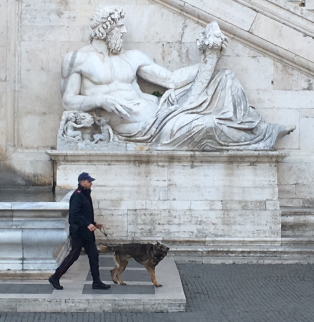A K-9 team walks past the statue representing the Tiber River in the Piazza del Campidoglio prior to the arrival of the EU heads of state for the ceremony to mark the 60th anniversary of the Treaty of Rome. March 25, 2017. Photo by Trisha Thomas