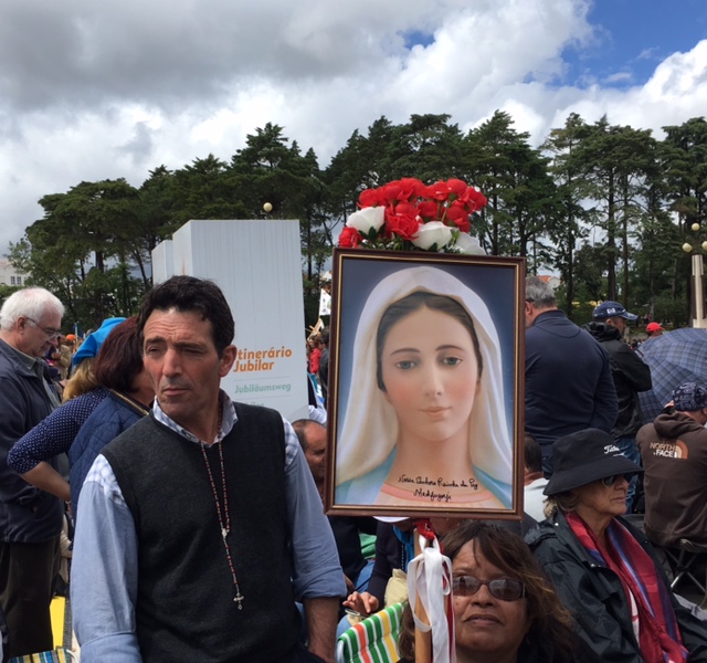 A pilgrim with a photo of Our Lady of Fatima at the canonization mass. May 13, 2017. Fatima, Portugal. Photo by Trisha Thomas