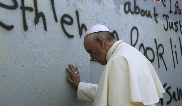 Pope Francis praying at the barrier wall between Israel and the Palestinian Territories. May 25, 2014. Credit: Osservatore Romano
