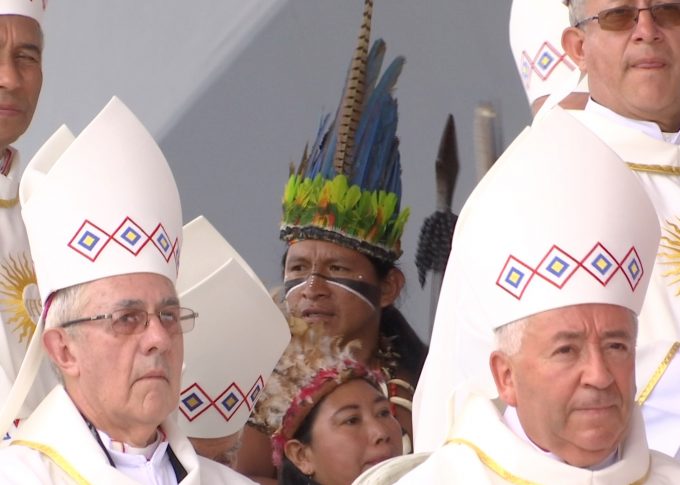 An indigenous man in traditional headdress appears between the bishops' miters at the Mass in Villavicencio, Colombia. September 8, 2017. Freeze frame of video shot by Gianfranco Stara for AP Television